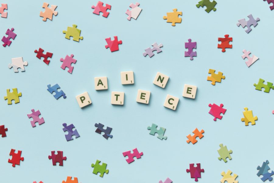 Scattered puzzle pieces and letter tiles on a pale surface.